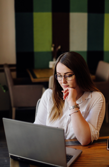 beautiful-woman-working-her-laptop-phone-stylish-urban-restaurant 1